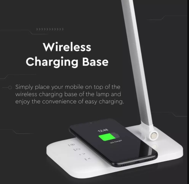 Mobile phone charging on a wireless charger of a LED desk lamp