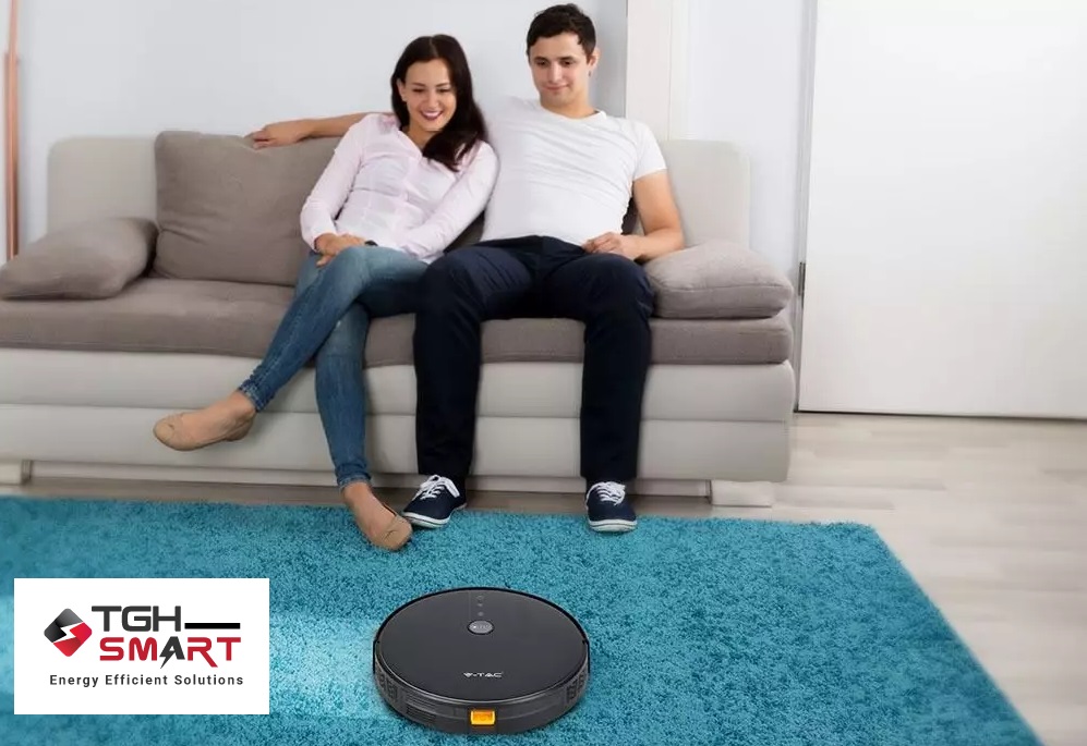 Smart robot vacuum cleaner hoovering while couple watch telly
